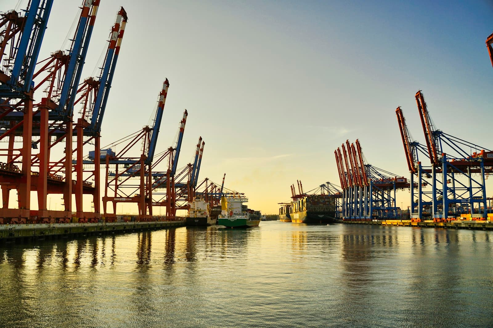 Container terminal cranes along a harbour at dusk