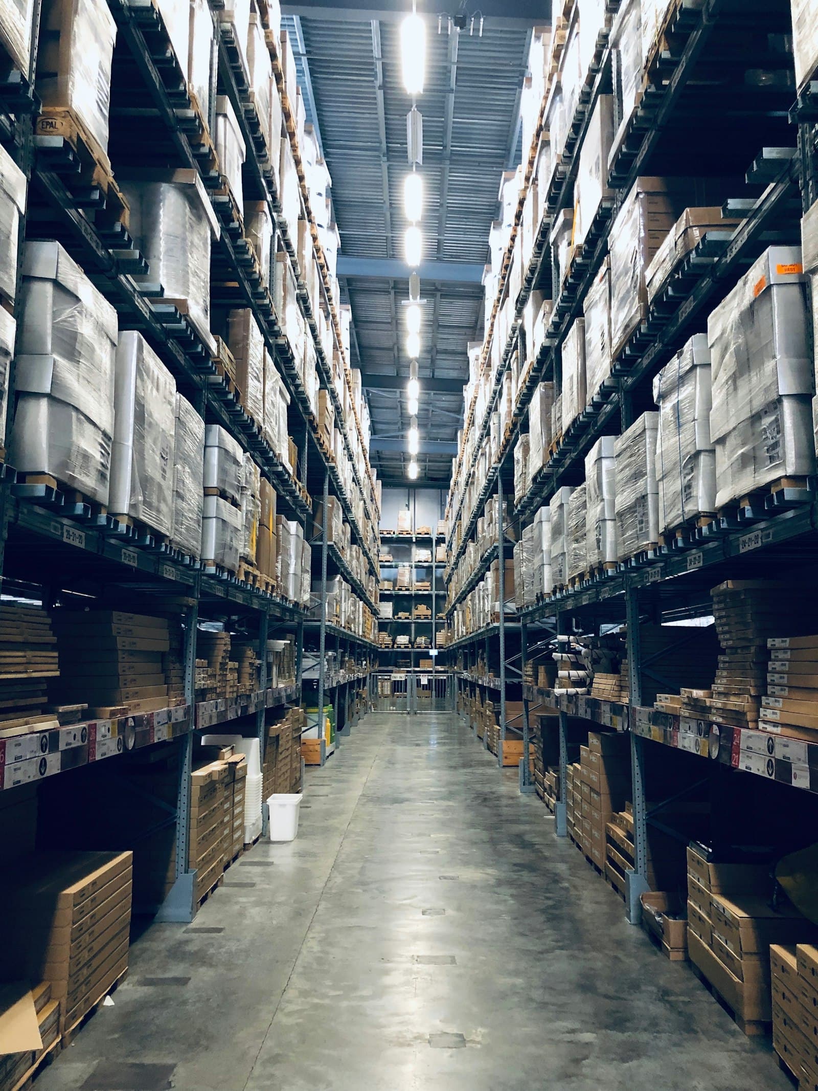 Aisle of a high-bay warehouse stacked with palletised stock